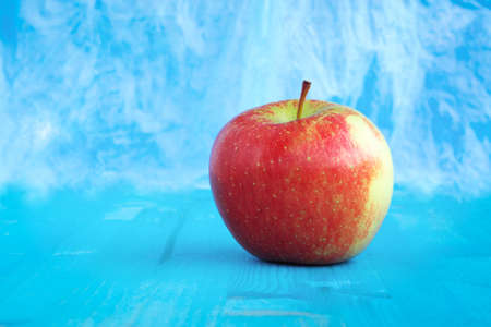 Red apple fuji on abstract  blue sky color background  - Isolated healthy organic fruit  front view on aquamarine wood with copy spaceの写真素材