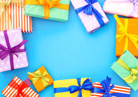 Colorful gift boxes flat frame on blue background for sale text - Top view wrapped presents of different colors for special offer - Holidays, Christmas and new year seasonal shopping conceptの写真素材