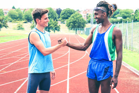Interracial friends greeting each other handshaking at the stadium running track - Runners shake hands in sign of mutual respect in life and in sport - Concept of friendship and  equality  Imageの写真素材