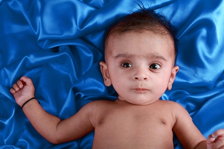 Baby boy with blue satin backgroundの写真素材