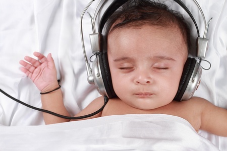 2 Month old baby listening to music with headphonesの写真素材