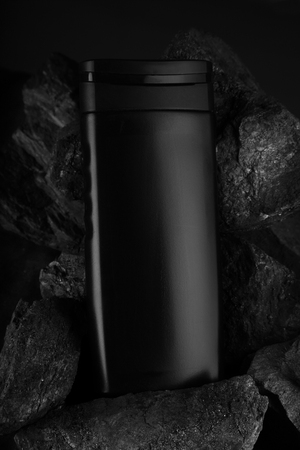 Black Blank Product Bottle on Black Charcoal for Mockupsの写真素材