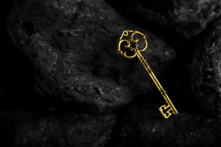 Golden Antique Key on Black Stone Backgroundの写真素材