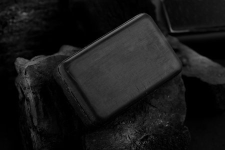 Black Charcoal Soap Bar on Black Coal Background