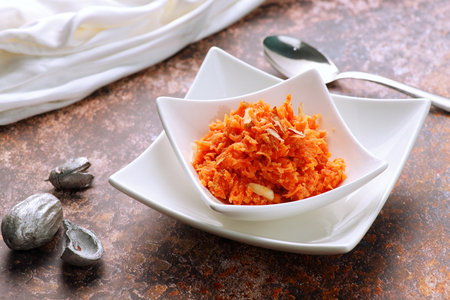 Indian Food Gajar ka Halwa (Carrot Sweet Pudding)  in a white Bowl with a Spoonの写真素材