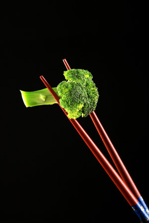 Food Broccoli on a Chop Sticks on Black Backgroundの写真素材
