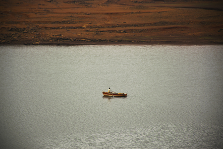 A boat rowed by fisherman in a riverの写真素材
