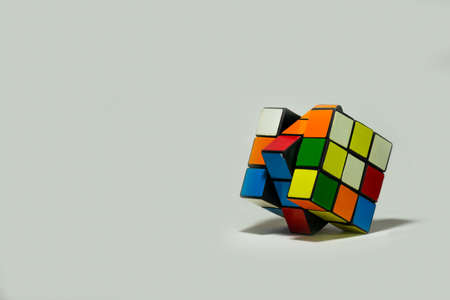A 3x3 Rubik's cube placed diagonally on a plain white background. The photograph has empty space for text.のeditorial素材
