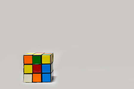 A 3x3 Rubik's cube placed diagonally on a plain white background. The photograph has empty space for text.のeditorial素材