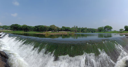 Panoramic landscape view of beautiful Kundmala waterfall with lush green trees around. It is a famous tourist place located on the coast of river Indrayani in Talegaon, Pune, Maharashtra, India.の写真素材