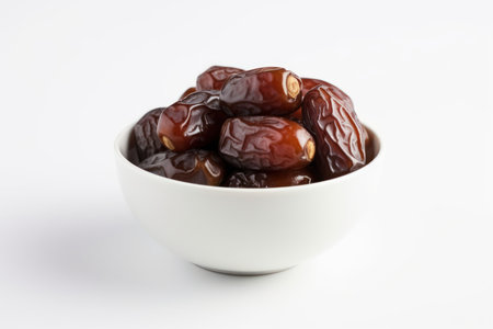 Dates fruit in a white bowl on white background, close upの素材