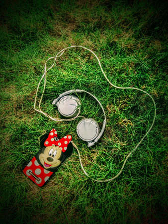 A mobilephone connected with a white wired headphoneの写真素材