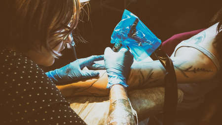 Tattoo artist make tattoo in studio, tattooing on the body. Floral tattooの写真素材
