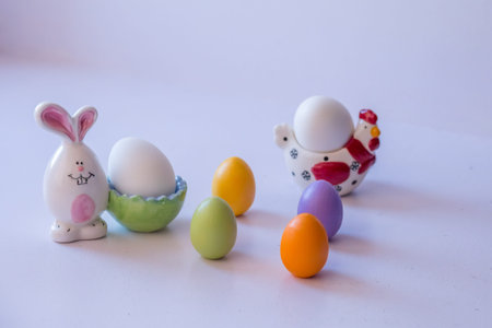 Easter composition: colorful eggs and a porcelain hare and chicken
