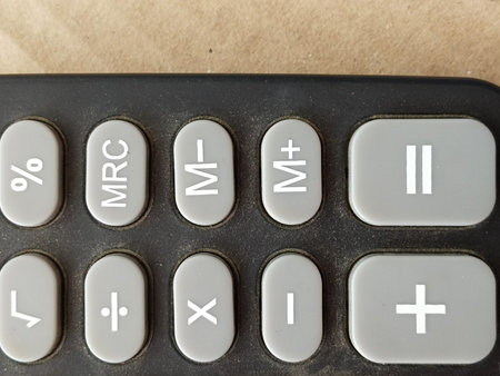 closeup single black digital calculator isolated on wheatish background, electronic office supplies...