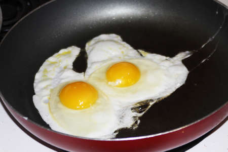Eggs, Sunnyside up being cooked in a frying pan の写真素材