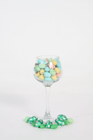 Wine glass filled with different colored candiesの写真素材