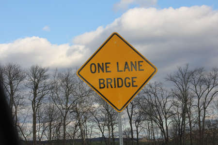 Yellow warning sign warning of one Lane Bridge aheadの写真素材