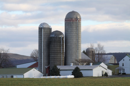 Farm buildings and Silos on a large expanse of farm land.