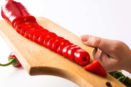 cutted red capa pepper hand holding on kitchen boardの写真素材