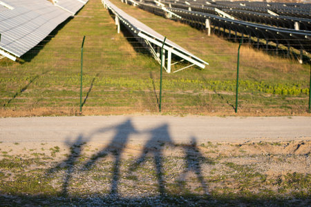 Shade of walking family, near solar power station