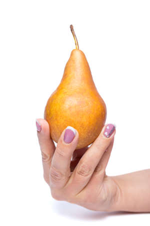 Fruit diet. Woman's hand holding yellow pear close up, isolated on a white.の写真素材