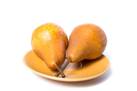 Two yellow pears on a plate, isolated on a white.の写真素材