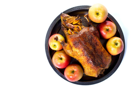 Baked duck with apples isolated on a white, view from a top, with copy space.の写真素材