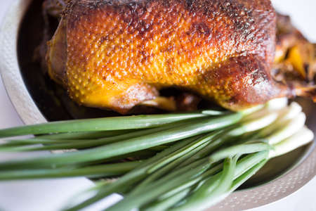 Stuffed baked duck in the oven with fresh green onion, on steel trayの写真素材