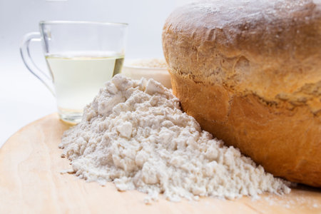 Baked wheat flour bread with ingredients close up, on a white background.
