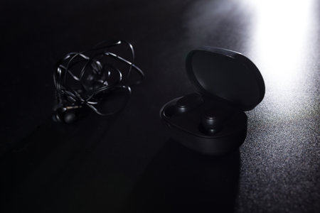 wireless headphones and classic wire headphones on black background.の写真素材