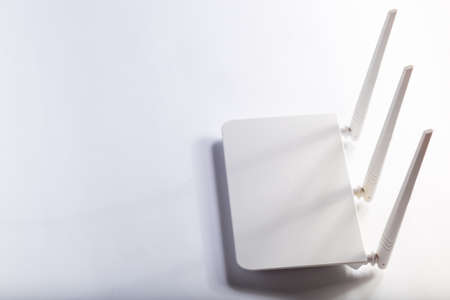 White wifi router with three antennas on a white background with copy space.の写真素材
