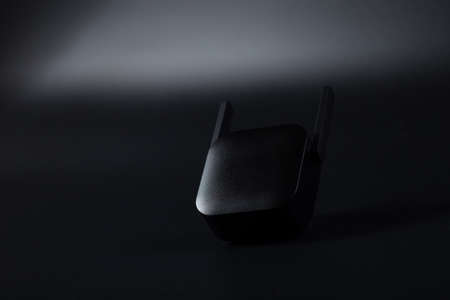 Black wifi amplifier close up, on black background, with copy space.の写真素材