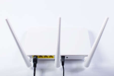 White wifi router with three antennas connecteed to network, on a white background.の写真素材
