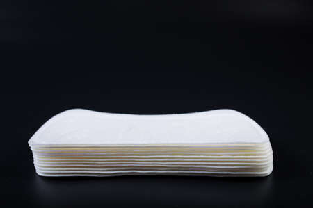 Woman's thin panty liners in a stack, on black background.の写真素材