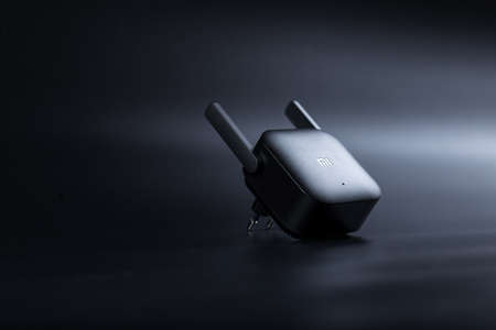Black WiFi Aplifier from Xiaomi with two antennas on black background with copy space.のeditorial素材