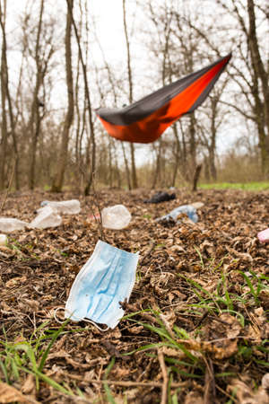 Used medical mask with plastick bottles in the camping area, on the wild forest.の写真素材