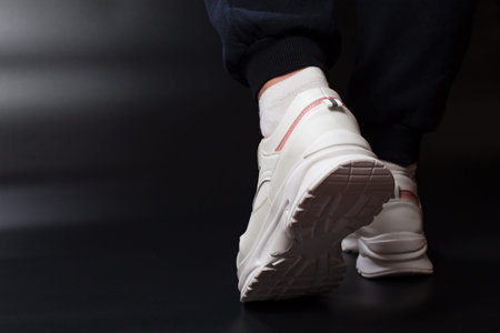 Foots wer sport shoes, close up on black background with copy space.