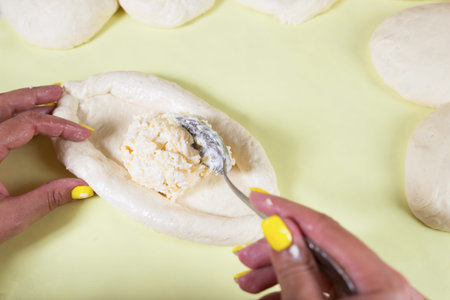 Baker female hands making Jorgian national bakery with cheesy stuff.