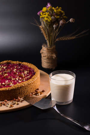 Breakfast table with cheeses cake and class of milk, on black background.の写真素材