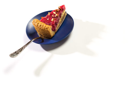 Piece of fruits cake on platter with shadow isolated on a white.