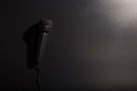 Simple black microphone close up on black background with cooy space.の写真素材