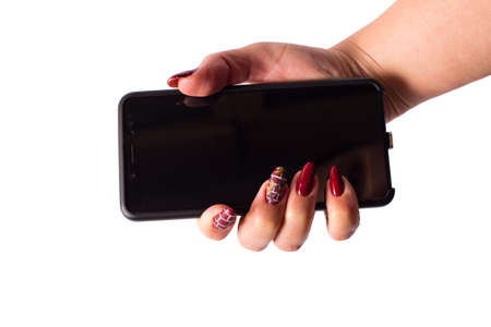 Female hand with manicure holding  black smart phone isolated on a white.の写真素材