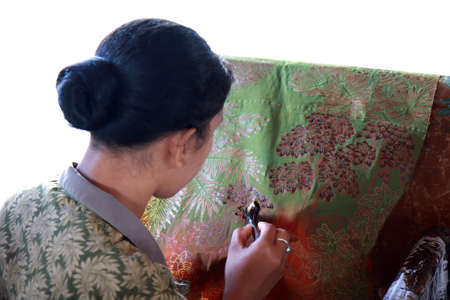 BALI, INDONESIA - AUGUST 26, 2011  An unidentified Balinese woman applies dye on a piece of batik cloth, on August 26, 2011 in Bali, Indonesia  Batik-making is an important part of Indonesian culture   のeditorial素材