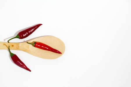 beam of red chilli pepper and wooden spoon on white backgroundの写真素材