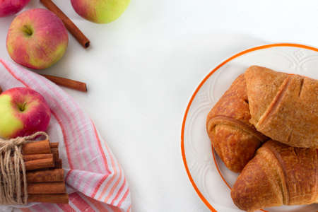 Fresh croissant with apple and cinnamon on white wooden background. Top view Copy spaceの写真素材