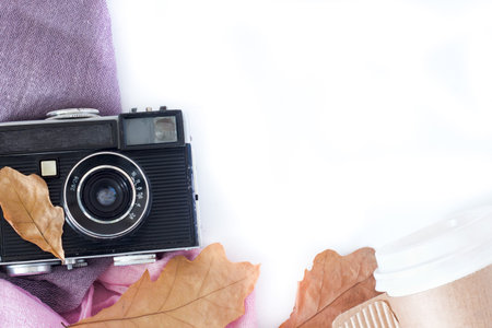 Retro camera and copy space with maple leaves in autumn border design - concept of remembrance and...