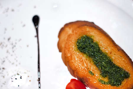 Tasty bread with garlic, cheese and herbs on white plate .の写真素材