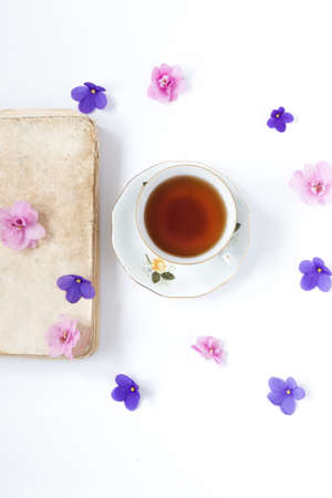 old retro book and cup of tea on white tableの写真素材