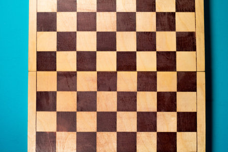 Wooden chessboard on turquoise background